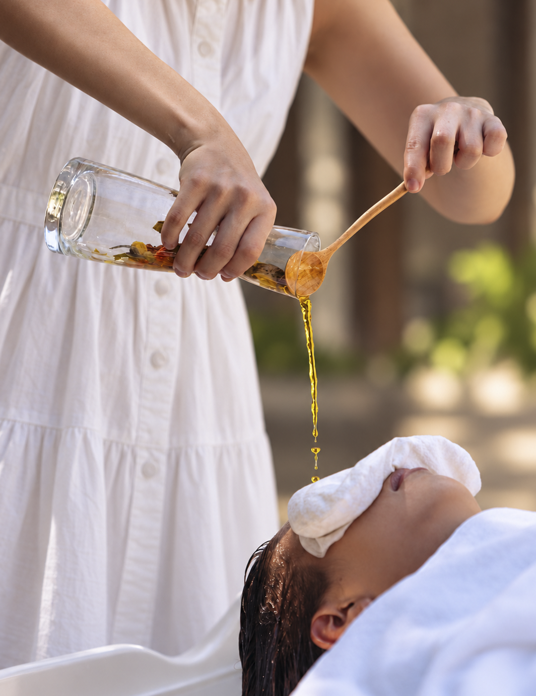 Ritual de Head SPA com óleo sendo servido de um vaso de vidro